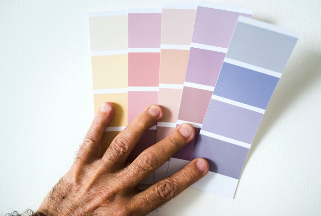 fingers of a male holding color palettes