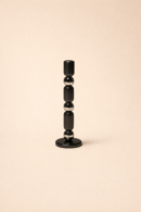 A decorative candle Stand staged on a console table