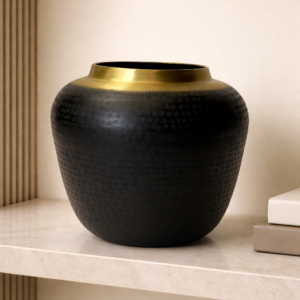 Matte black round vase with textured column design and subtle gold detailing displayed as a modern decor piece.